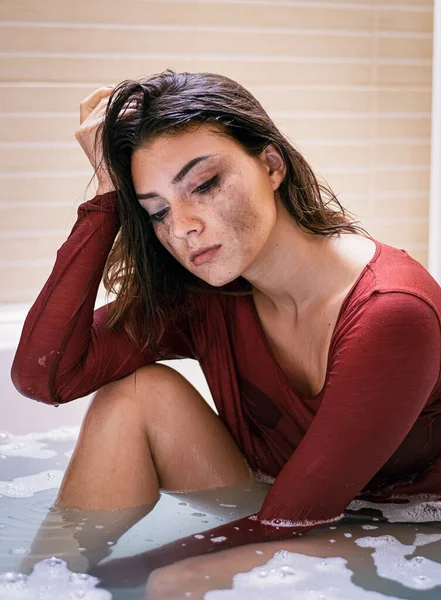 Depressed women sitting in the bathtub