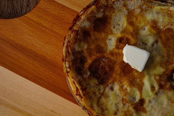 Tahtanın üzerinde ev yapımı krepler var. Tüm aile için lezzetli geleneksel kahvaltı tatlısı. Metin için yeri olan arkaplan resmi.