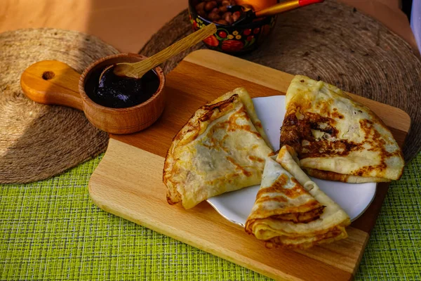 Samimi ev yapımı gözlemeler bir fincan tabağında üçgen şeklinde yuvarlandı. Ve küçük bir kaseye sıkıştır. Tatlı olarak lezzetli yemekler.