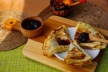 Samimi ev yapımı gözlemeler bir fincan tabağında üçgen şeklinde yuvarlandı. Ve küçük bir kaseye sıkıştır. Tatlı olarak lezzetli yemekler.