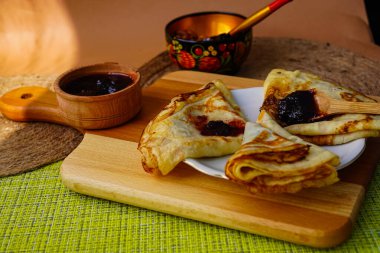 Samimi ev yapımı gözlemeler bir fincan tabağında üçgen şeklinde yuvarlandı. Ve küçük bir kaseye sıkıştır. Tatlı olarak lezzetli yemekler.