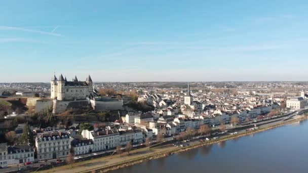 中世の城と教会が日の出 ロワール渓谷 フランスの川に反映しているSaumur町のスカイライン 空中ドローンドーリーショット 旅行ズームアウト 風景や町を明らかに — ストック動画