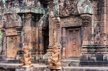 Mitolojik savaşçıların iki taş oyması Banteay Srei antik tapınağının girişini koruyor, Angkor Wat Unesco parkında, Siem Reap, Kamboçya