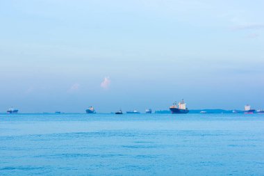 Kargo gemileri, petrol tankerleri ve gemi gemileri Singapur Dümeni boyunca demir attı, Singapur 'da, gün batımında.