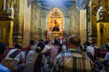Mandalay, Myanmar - 3 Haziran 2014: Budist bir rahip, büyük bir Budist kalabalığının katıldığı günlük bir tören olan Mahamuni Phaya 'da bir Buda heykelinin yüzünü yıkadı