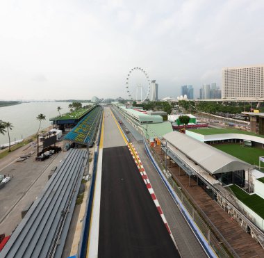 Singapur - 9 Eylül 2019: Marina Körfezi Caddesi pisti Singapur Gece Yarışı Formula 1 Grand Prix 'ini karşılamaya hazırlanıyor. Tribün Flyer Dönme dolabının, körfezdeki bahçelerin ve Sands tatil beldelerinin üzerinden bakıyor..