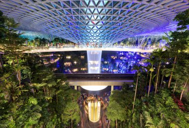 Singapur-30 Aug 2019: Jewel Changi, Singapur Havaalanı ışık gösterisi sırasında. Yeni cam kubbe terminalinde dikey bir şelale, tropikal bir orman, alışveriş ve yemek alanları yer alıyor.