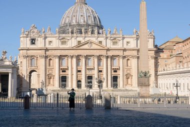 Roma, İtalya - 12 Mart 2020: Bir turist Vatikan 'daki boş Aziz Peter Meydanı önünde selfie çekiyor. Koronavirüs salgınının ardından İtalya şu anda tecrit altında ve turistik alanlar terk edilmiş durumda..