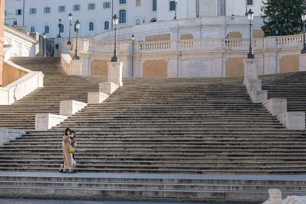 Roma, İtalya - 10 Mart 2020: İki kadın turist, Roma, İtalya 'daki boş İspanyol Merdivenleri önünde selfie çekiyor. Bugün itibarıyla, İtalyan hükümeti ülke çapında bir karantina ilan etti. Seyahat ve toplama yasakları, mağazalar için sınırlı çalışma saatleri ve...