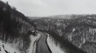 Karlı dağlar ve arabalar arasındaki donmuş yol.