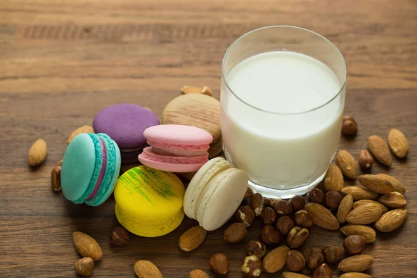 Leckere Makronen Und Eine Tasse Milch Auf Hölzernem Hintergrund — Stockfoto