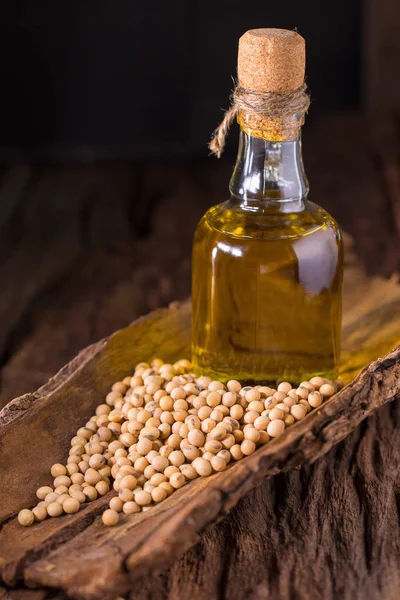 Soybeans and soy oil on wooden table