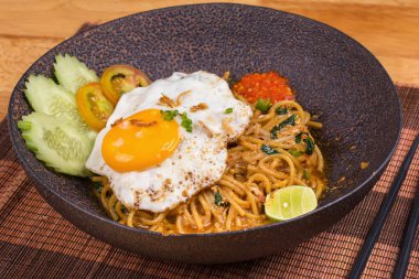 Spagetti ve ahşap masa üzerinde kızarmış yumurta ilave edin