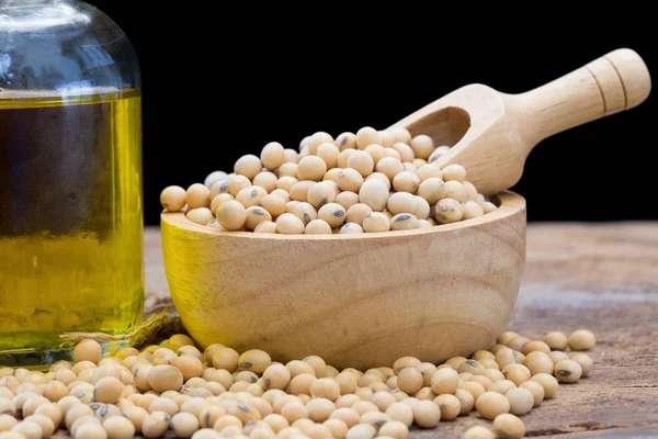 Soy bean and soy oil on wooden table.