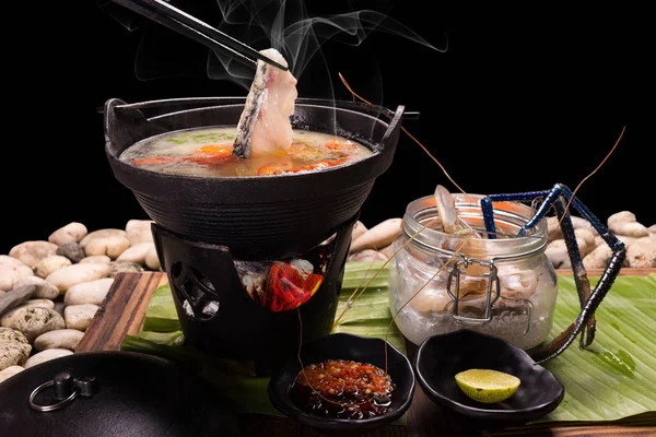 Food served in a pot Japan where the sea food shabu-shabu of the sea bream is hot on black background
