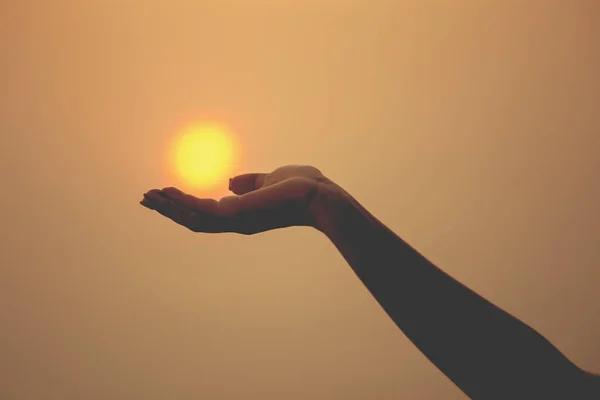 Sun on female hand. Silhouette of hand holding sun