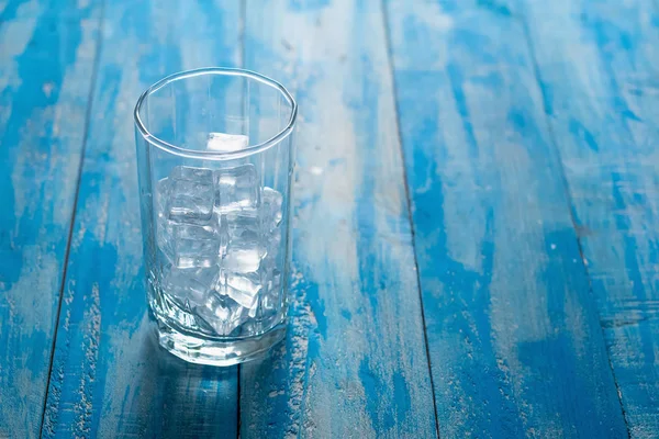 青い木製テーブルの上のガラスのアイス キューブ — ストック写真