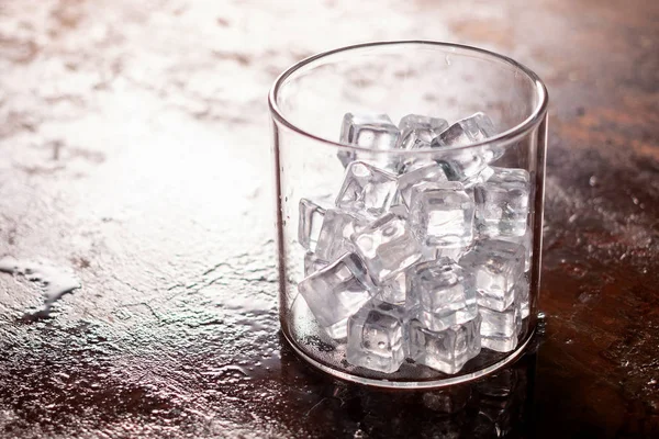 Glass of Ice cubes on wooden table