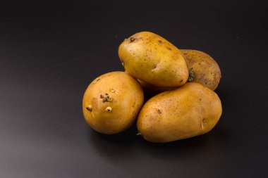 Siyah arka plan üzerine pişmemiş taze patates