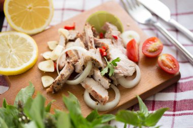 Limon ile dilimlenmiş domuz ile sarımsak ve biber ahşap tahta üzerinde baharatlı sos