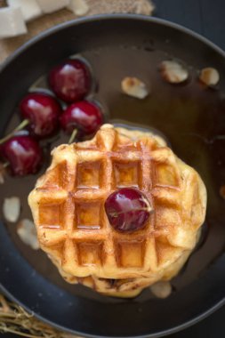 Koyu ahşap arka plan üzerinde kiraz çilek ile waffle üzerinde tatlım. Kahvaltı konsepti.
