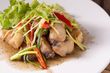 Tay tarzında baharatlı deniz ürünleri sos ile balık soslu kızarmış kral uskumru balıkla.