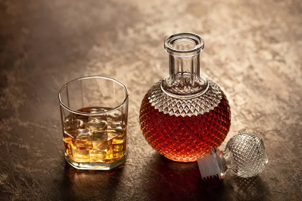 Şişe viski ve viski siyah arka plan üzerine buzlu cam