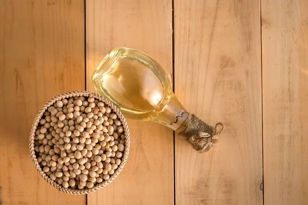 Soybeans and soy oil on wooden table