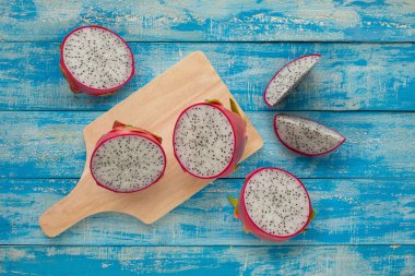 Tropikal dragon meyve mavi ahşap masa arka plan üzerinde