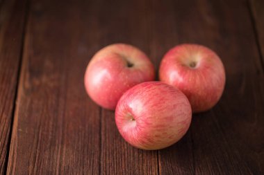 Tahta arka planda olgun kırmızı elmalar