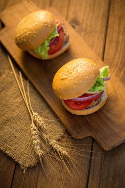 Peynirli hamburger ızgara et, peynir, domates Ahşap yüzeyi ile