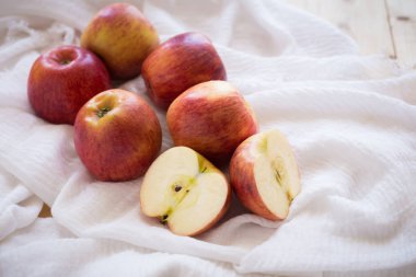 Ahşap arka plan üzerinde beyaz kumaş üzerine kırmızı elmalar