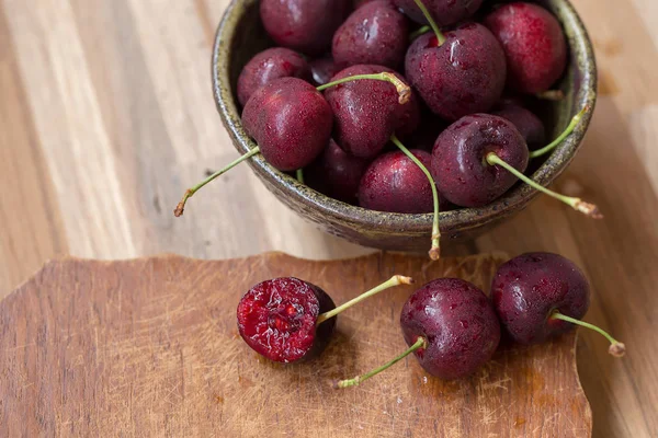 Cuenco de cerezas. Cerezas rojas en un tazón sobre fondo de madera —  Fotos de Stock