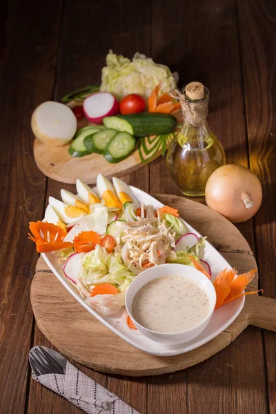 Beyaz tabakta tavuk ve haşlanmış yumurta taze yeşil salata