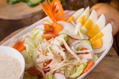 Beyaz tabakta tavuk ve haşlanmış yumurta taze yeşil salata