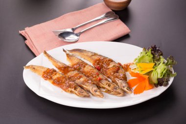 Beyaz tabakta chili soslu kızarmış sheatfish