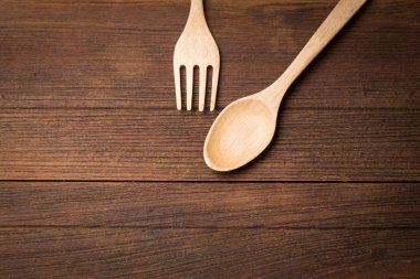 Ahşap arka plan üzerinde ahşap çatal ve kaşık üstten görünüm