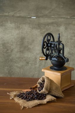 rustik ahşap zemin üzerine çuval bezi ve vintage kahve makinesi kahve çekirdekleri ile çuval