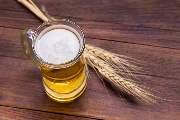 Xícara de cerveja na mesa de madeira . — Fotografia de Stock