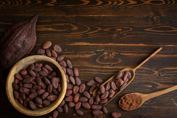 Cocoa beans and cocoa pod on old natural wooden background — Stock Photo, Image