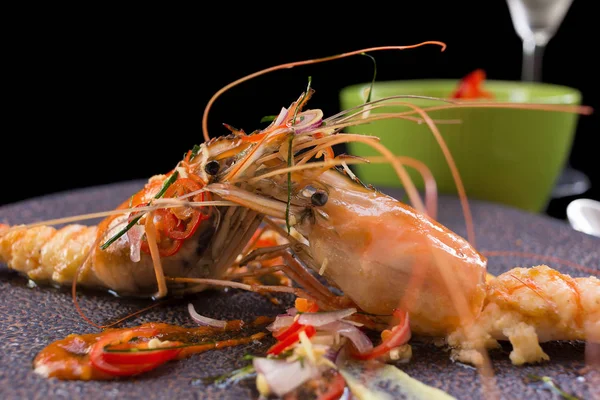 stock image grilled shrimps served with spicy sauce on black background