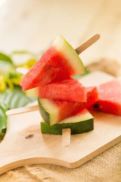 karpuz parçalar kahverengi ahşap masa üzerinde sopa üzerinde.