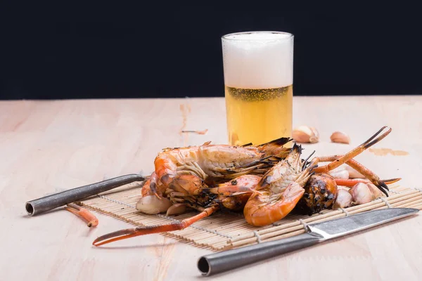 Burn shrim and Seafood sauce with beer on wooden table. — Stock Photo, Image