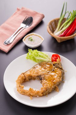Beyaz tabakta derin kızarmış balık balık sosu ile