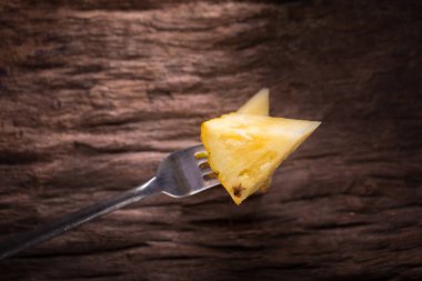 Ananas dilimleri ve eski ahşap arka plan üzerinde kabuklu ananas