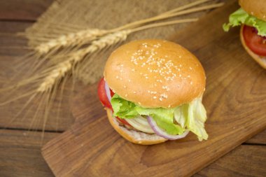 Peynirli hamburger ızgara et, peynir, domates Ahşap yüzeyi ile