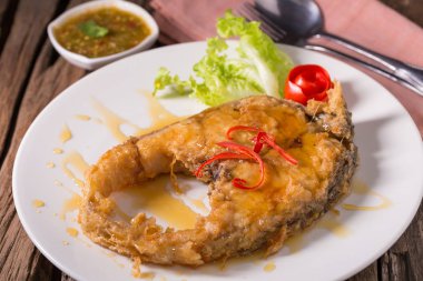 Beyaz tabakta derin kızarmış balık balık sosu ile