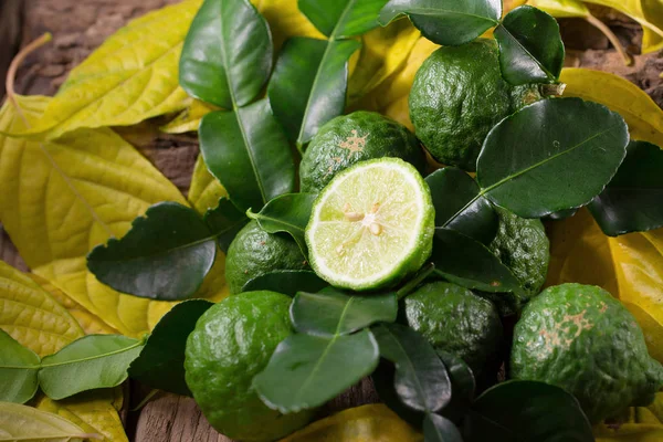 Čerstvý bergamot a žluté listy na staré dřevěné stoly pozadí — Stock fotografie