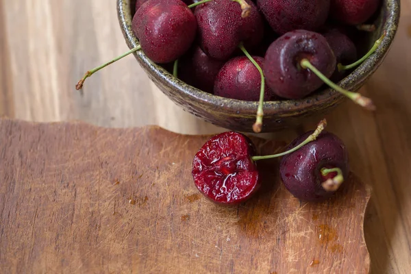 Cuenco de cerezas. Cerezas rojas en un tazón sobre fondo de madera —  Fotos de Stock