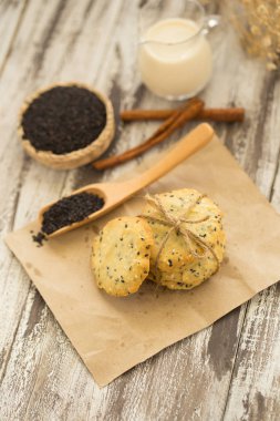 Susam kurabiye, susam ve siyah ahşap zemin üzerine süt